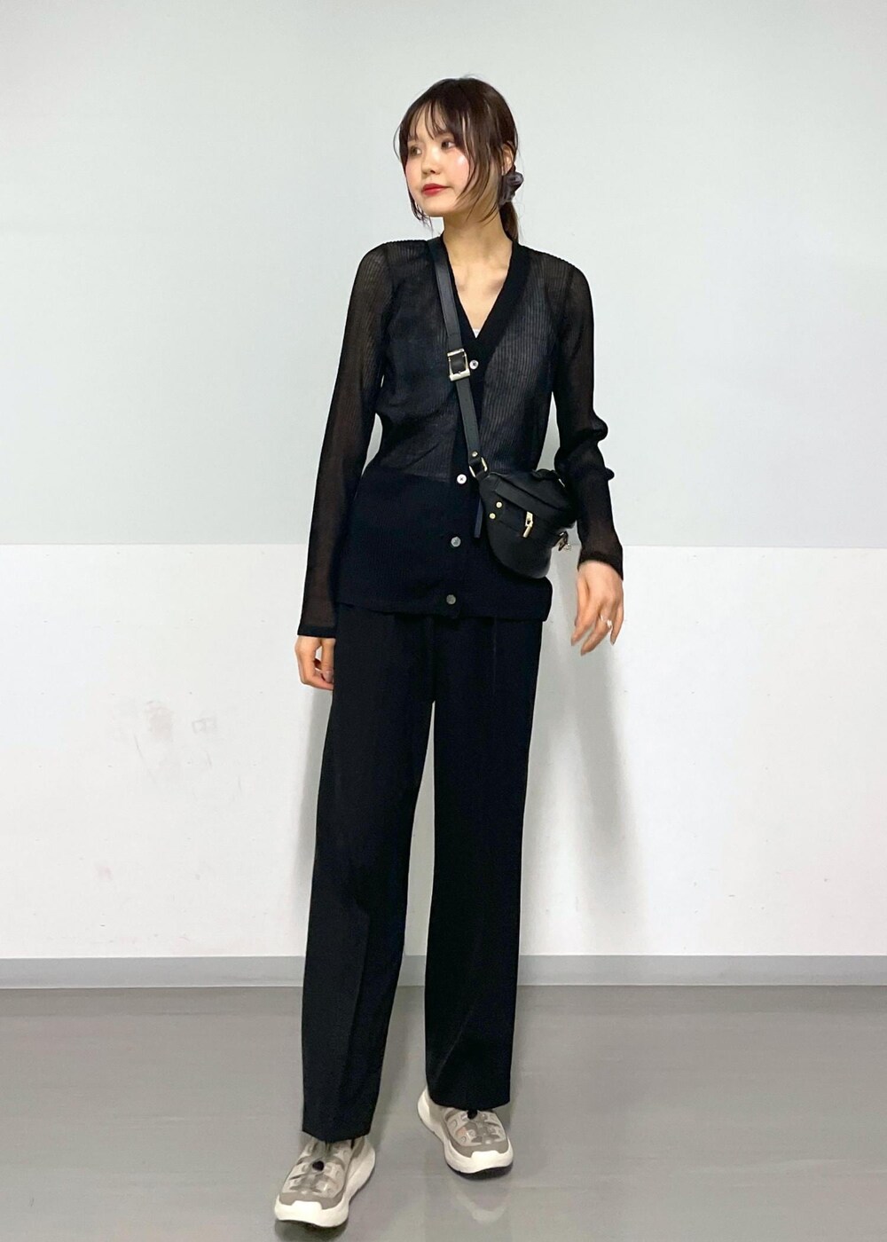 グレー系のタンクトップ、ブラック系のボディバッグ/ウエストポーチ、ブラック系のカーディガン/ボレロを着用したレディースの春コーディネートの4枚目の写真