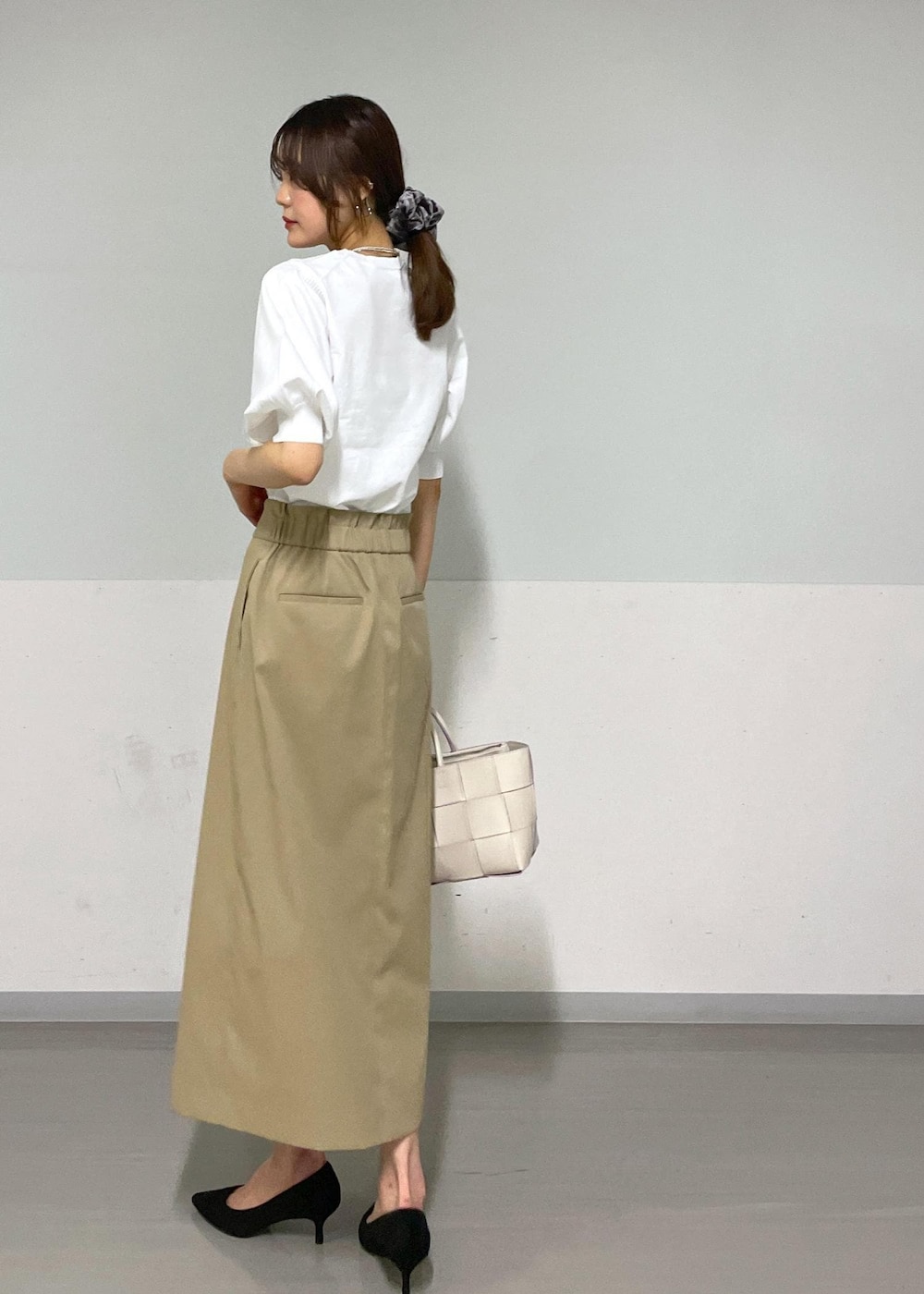 ホワイト系のトートバッグ、ベージュ系のスカート、ベージュ系のカーディガン/ボレロを着用したレディースの夏コーディネートの3枚目の写真