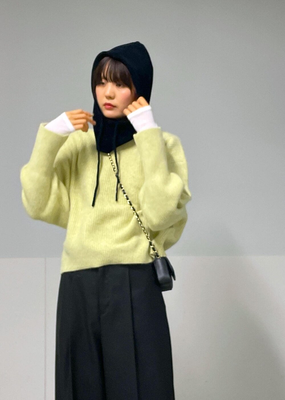 ブラック系のショルダーバッグ、イエロー系のニット/セーター、ホワイト系のTシャツ/カットソーを着用したレディースの秋コーディネートの5枚目の写真