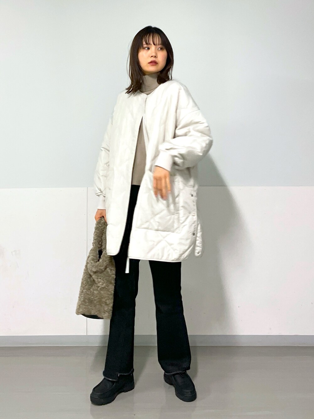 グレー系のブルゾン、グレー系のデニムパンツ、ブラック系のスニーカーを着用したレディースの冬コーディネートの2枚目の写真