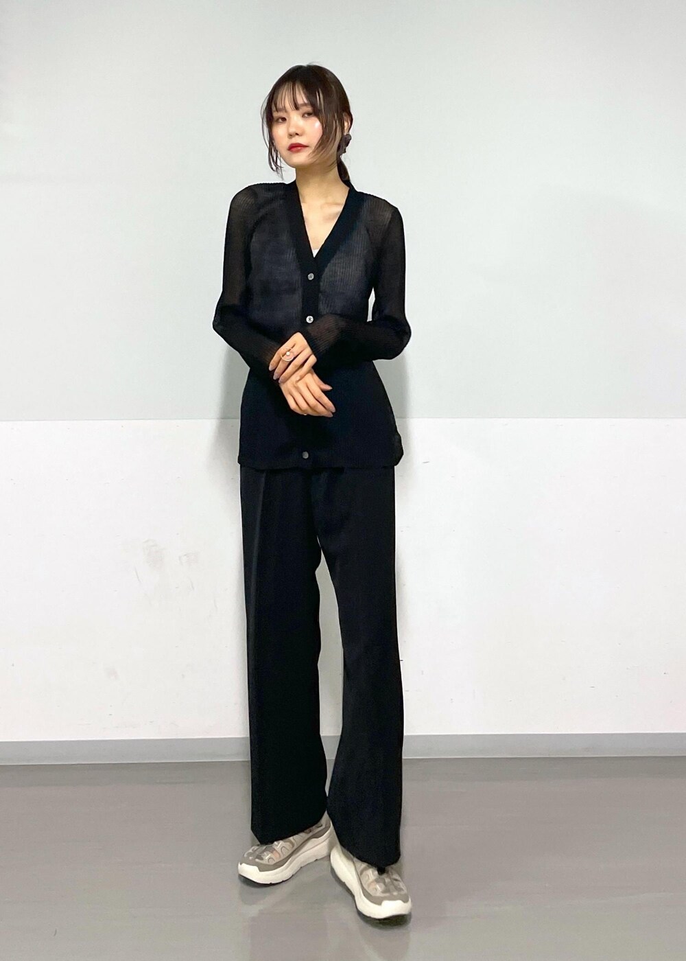 グレー系のタンクトップ、ブラック系のボディバッグ/ウエストポーチ、ブラック系のカーディガン/ボレロを着用したレディースの春コーディネートの9枚目の写真