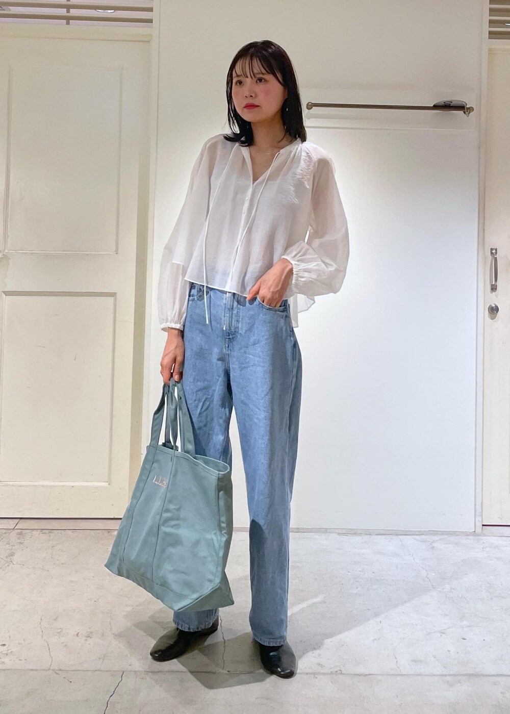 グレー系のタンクトップ、ホワイト系のシャツ/ブラウス、ブルー系のデニムパンツを着用したレディースの夏コーディネートの7枚目の写真