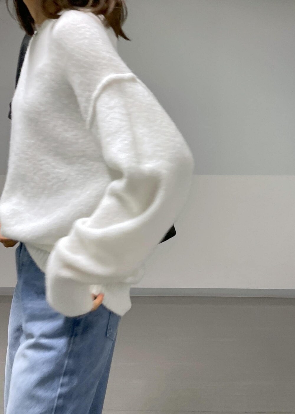 ブラック系のバレエシューズ、ブルー系のデニムパンツ、ホワイト系のニット/セーターを着用したレディースの秋コーディネートの6枚目の写真
