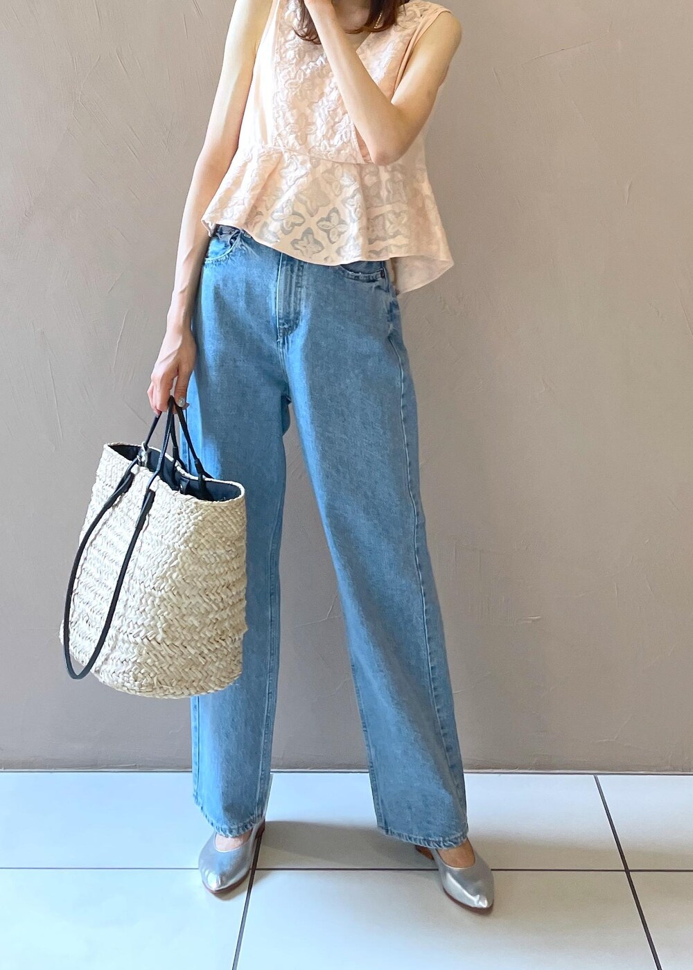 ホワイト系のかごバッグ、ブルー系のデニムパンツ、シルバー系のパンプスを着用したレディースの夏コーディネートの8枚目の写真