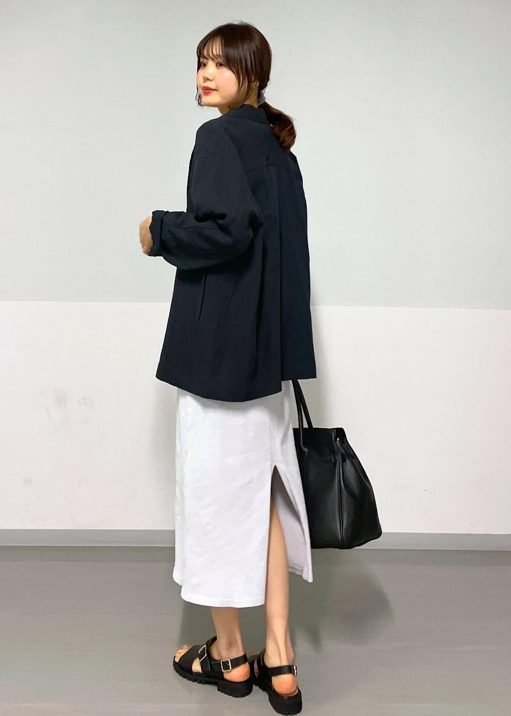 ブラック系のサンダル、グレー系のワンピース、ホワイト系のTシャツ/カットソーを着用したレディースの冬コーディネートの6枚目の写真