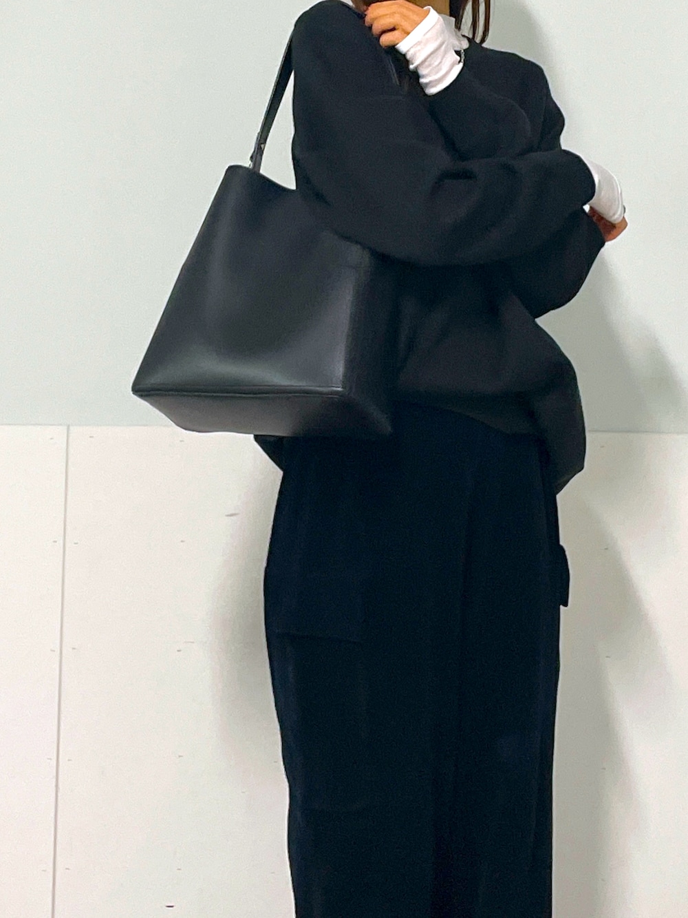 ブラック系のスウェット、ブラック系のカーゴパンツ、ホワイト系のTシャツ/カットソーを着用したレディースの秋コーディネートの4枚目の写真