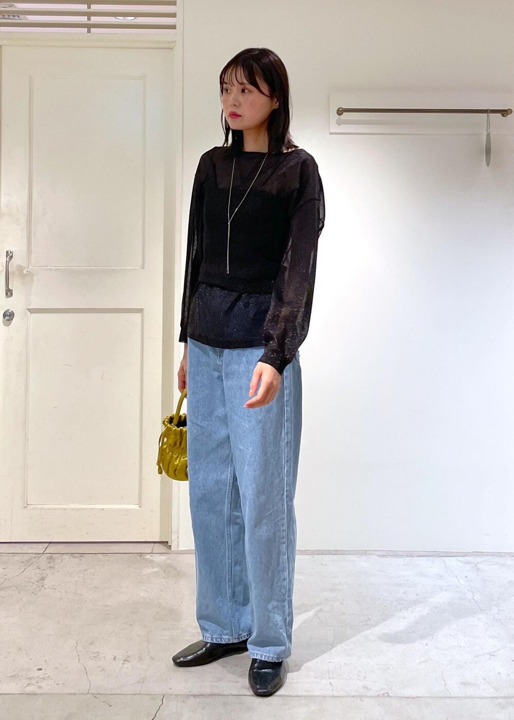 イエロー系のショルダーバッグ、ブルー系のデニムパンツ、ブラック系のTシャツ/カットソーを着用したレディースの夏コーディネートの4枚目の写真