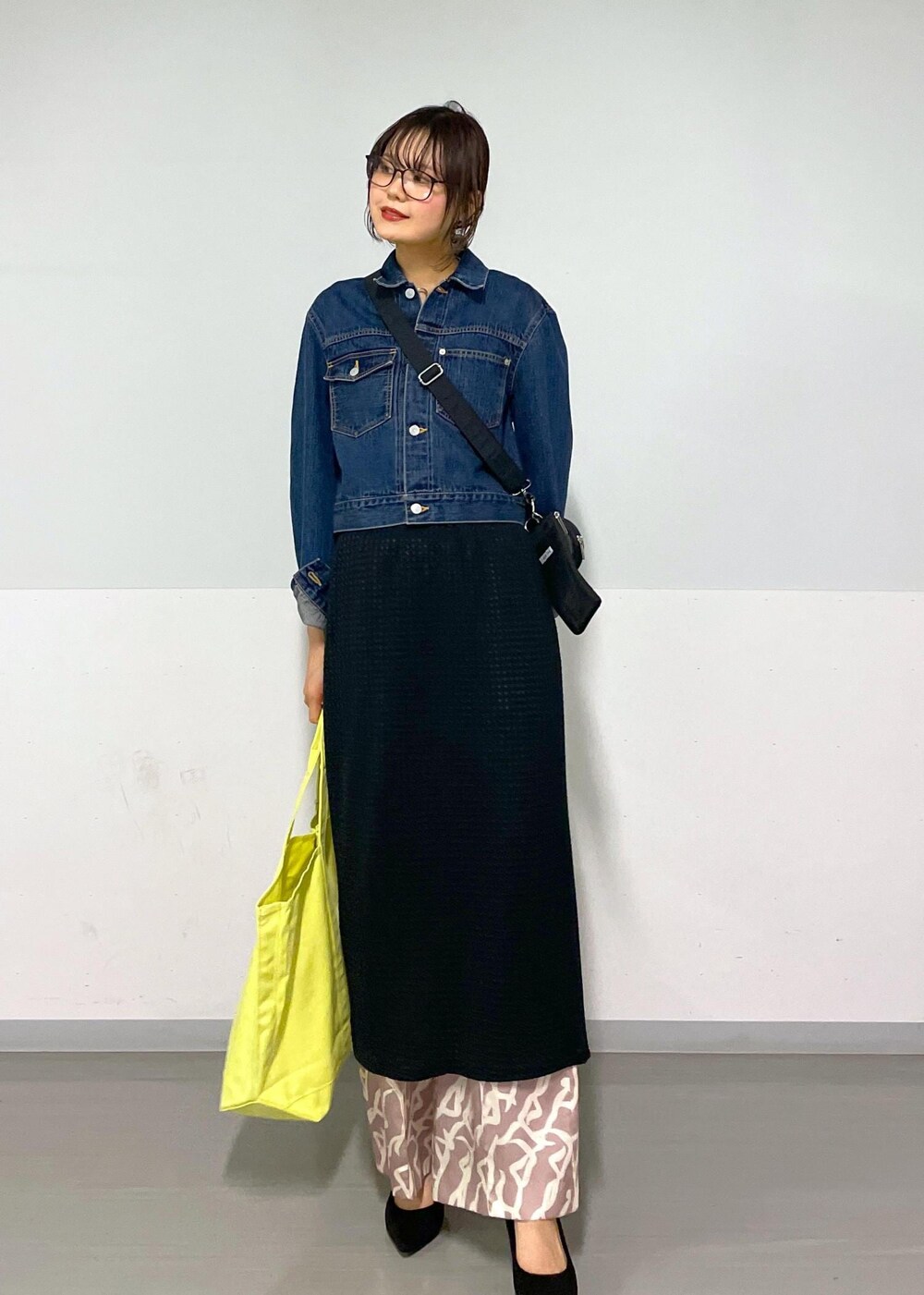 イエロー系のその他パンツ、ブラック系のスカート、ブラック系のトートバッグを着用したレディースの春コーディネートの2枚目の写真