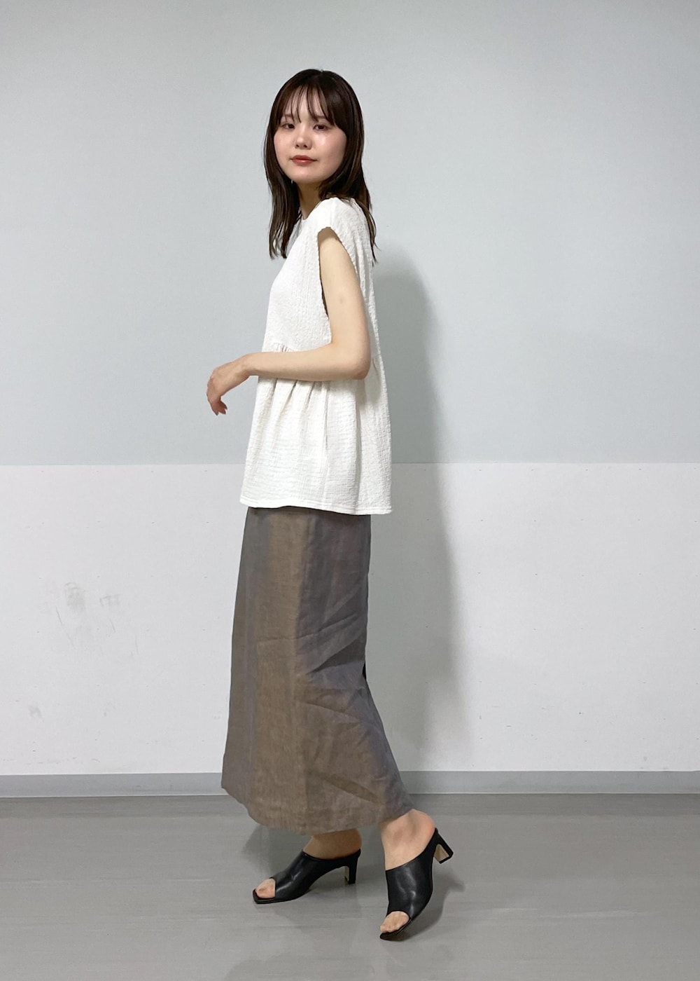 ホワイト系のTシャツ/カットソー、ブラック系のサンダル、ブラック系のトートバッグを着用したレディースの夏コーディネートの2枚目の写真