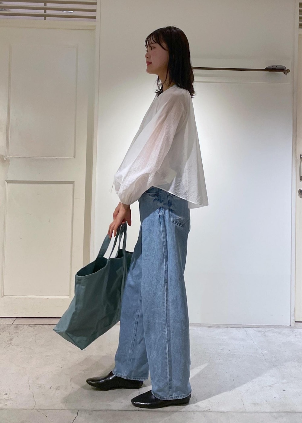 グレー系のタンクトップ、ホワイト系のシャツ/ブラウス、ブルー系のデニムパンツを着用したレディースの夏コーディネートの3枚目の写真