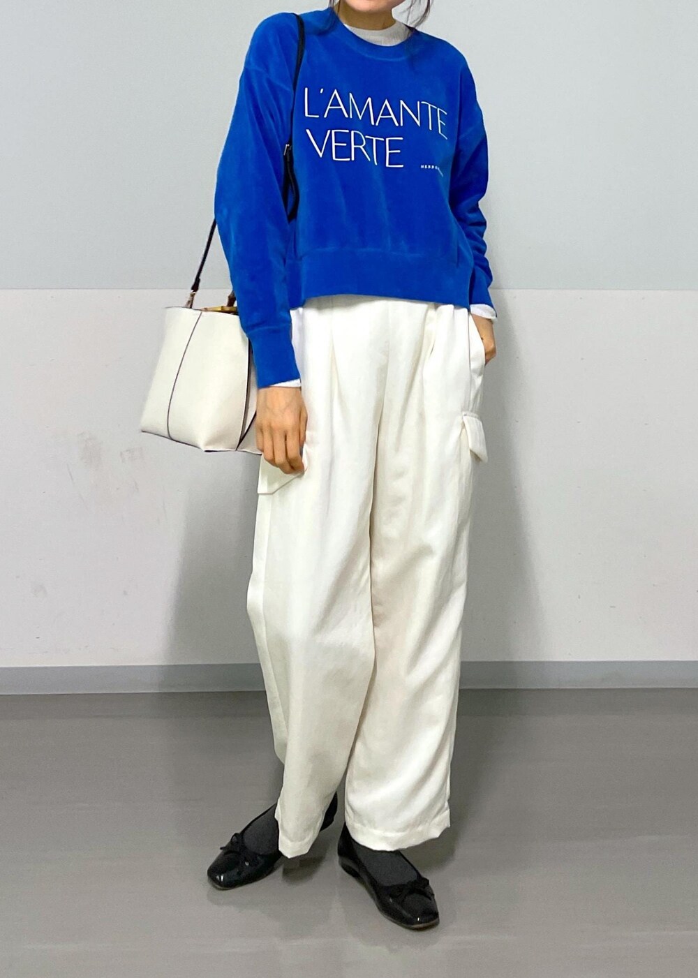 ブルー系のニット/セーター、ホワイト系のカーゴパンツ、ホワイト系のTシャツ/カットソーを着用したレディースの冬コーディネートの9枚目の写真