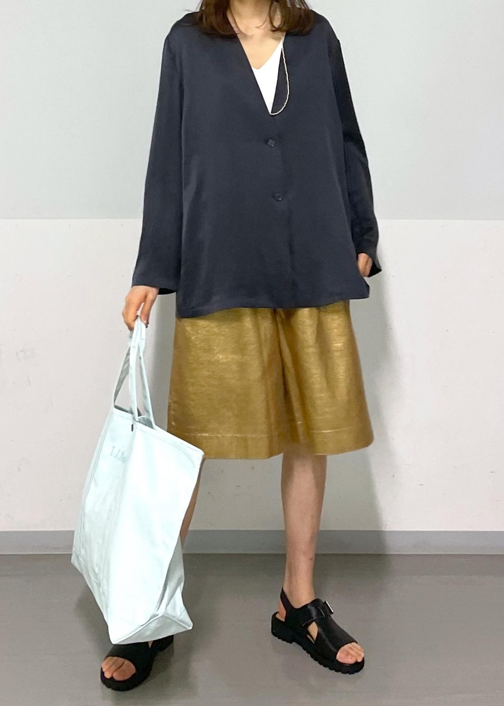 ゴールド系のその他パンツ、グレー系のノーカラージャケット、ブラック系のサンダルを着用したレディースの春コーディネートの4枚目の写真