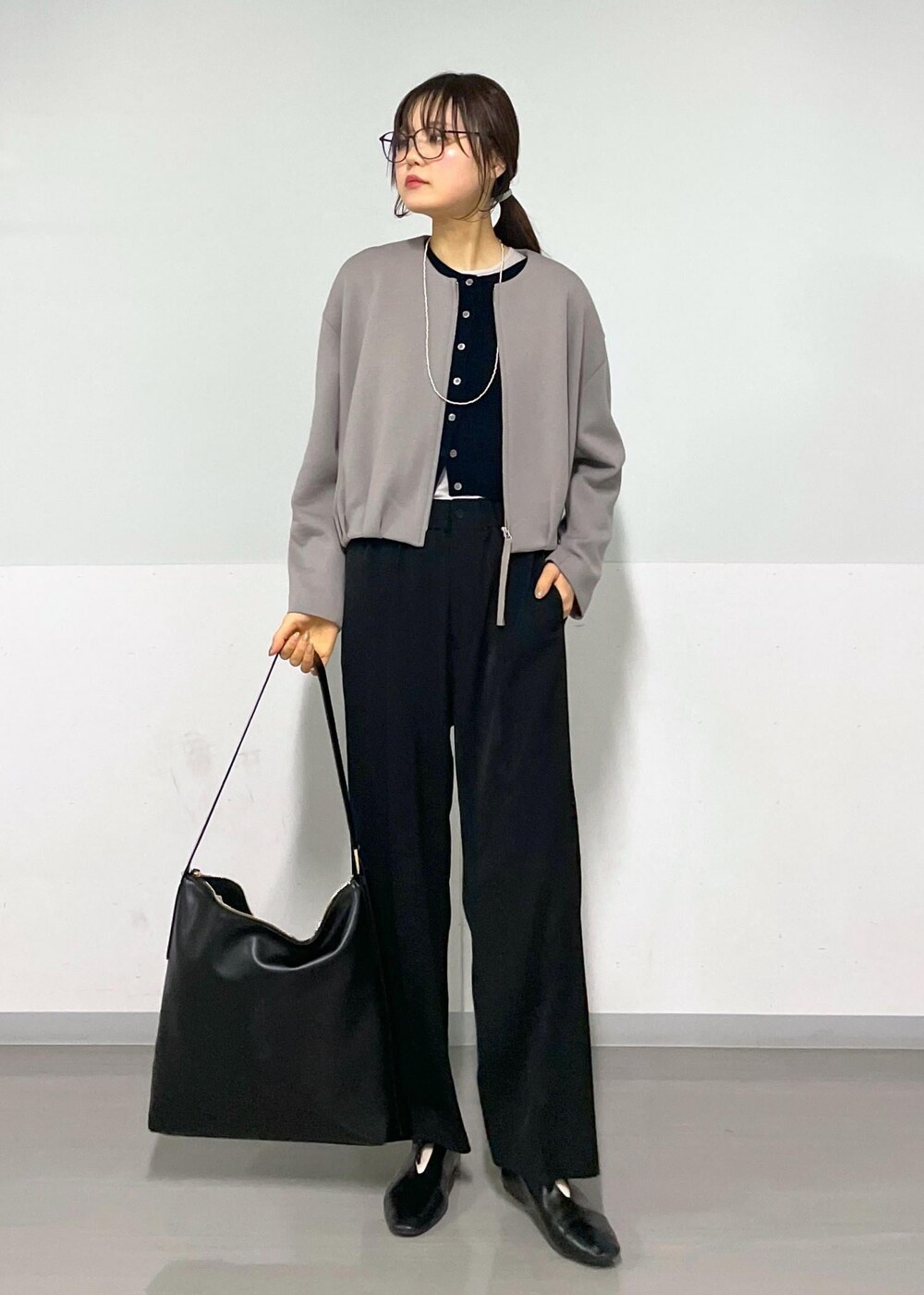 ブラック系のカーディガン/ボレロ、グレー系のTシャツ/カットソー、ブラック系のショルダーバッグを着用したレディースの春コーディネートの2枚目の写真