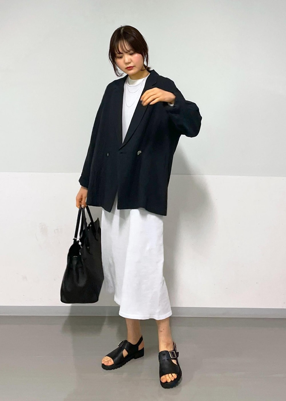 ブラック系のサンダル、グレー系のワンピース、ホワイト系のTシャツ/カットソーを着用したレディースの冬コーディネートの3枚目の写真