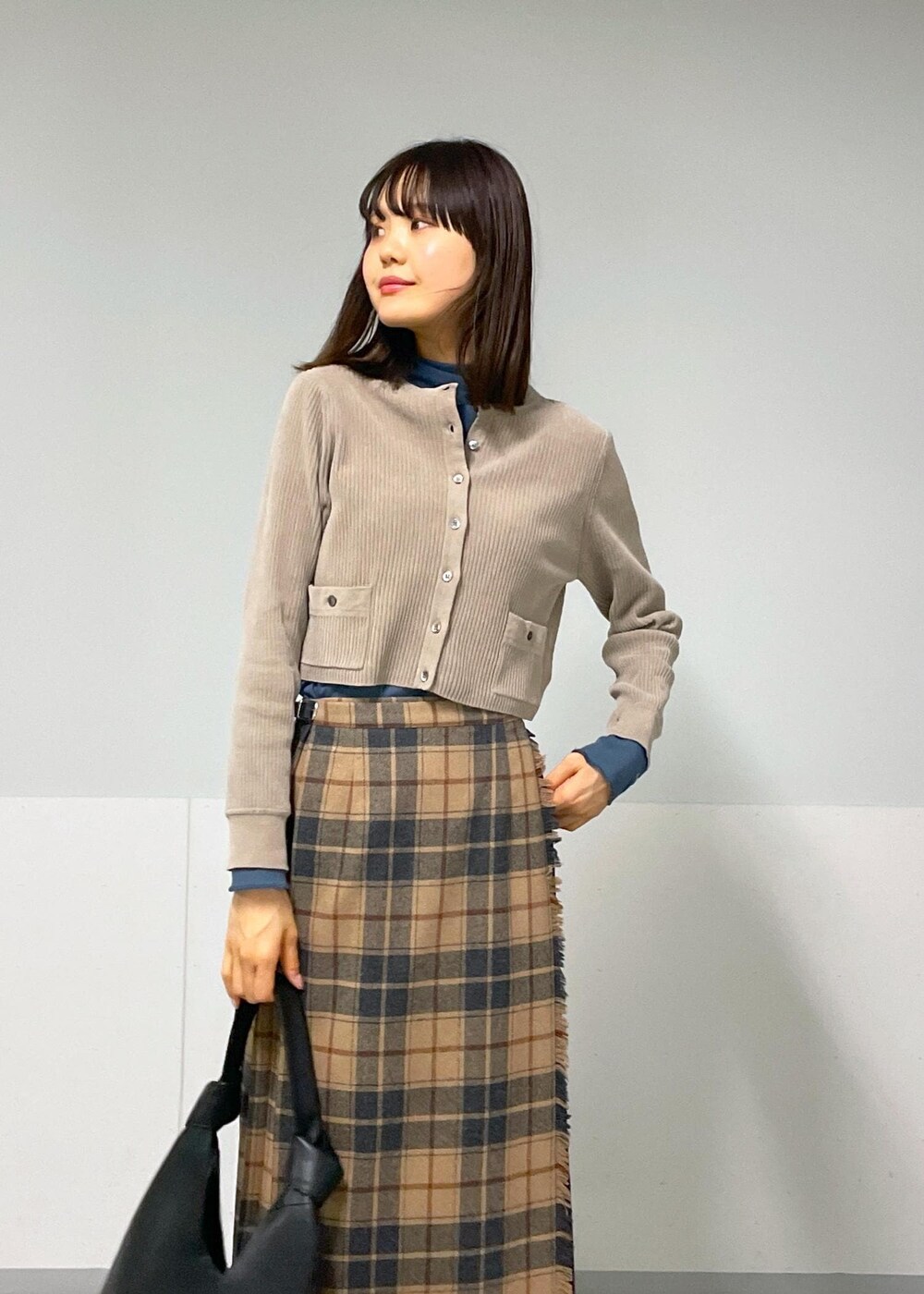 ブルー系のTシャツ/カットソー、ベージュ系のスカート、グレー系のカーディガン/ボレロを着用したレディースの秋コーディネートの8枚目の写真