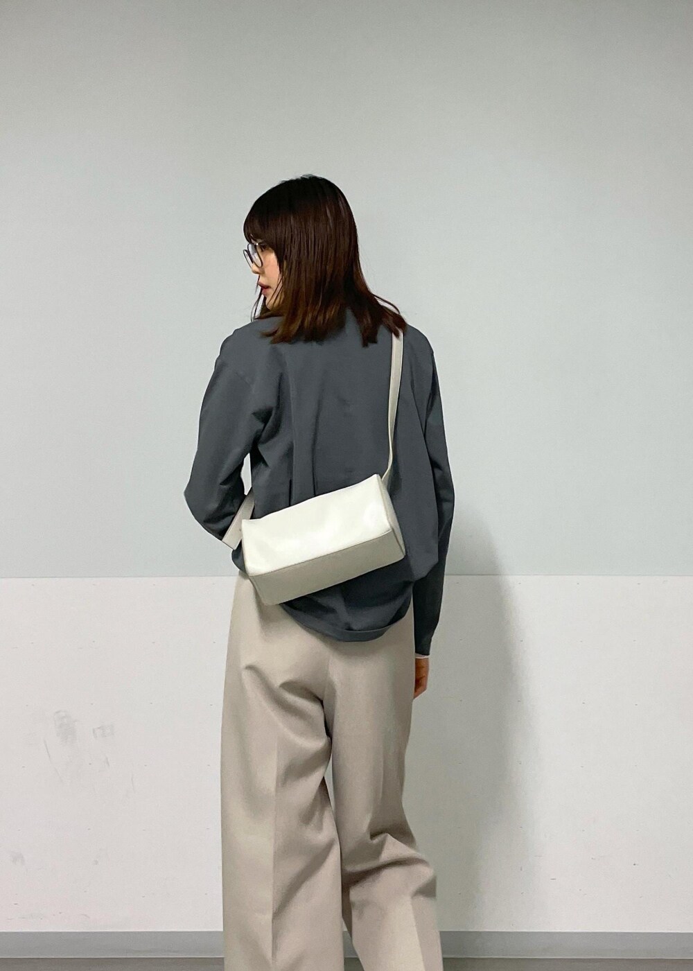 グレー系のショルダーバッグ、ベージュ系のその他パンツ、グレー系のTシャツ/カットソーを着用したレディースの秋コーディネートの10枚目の写真