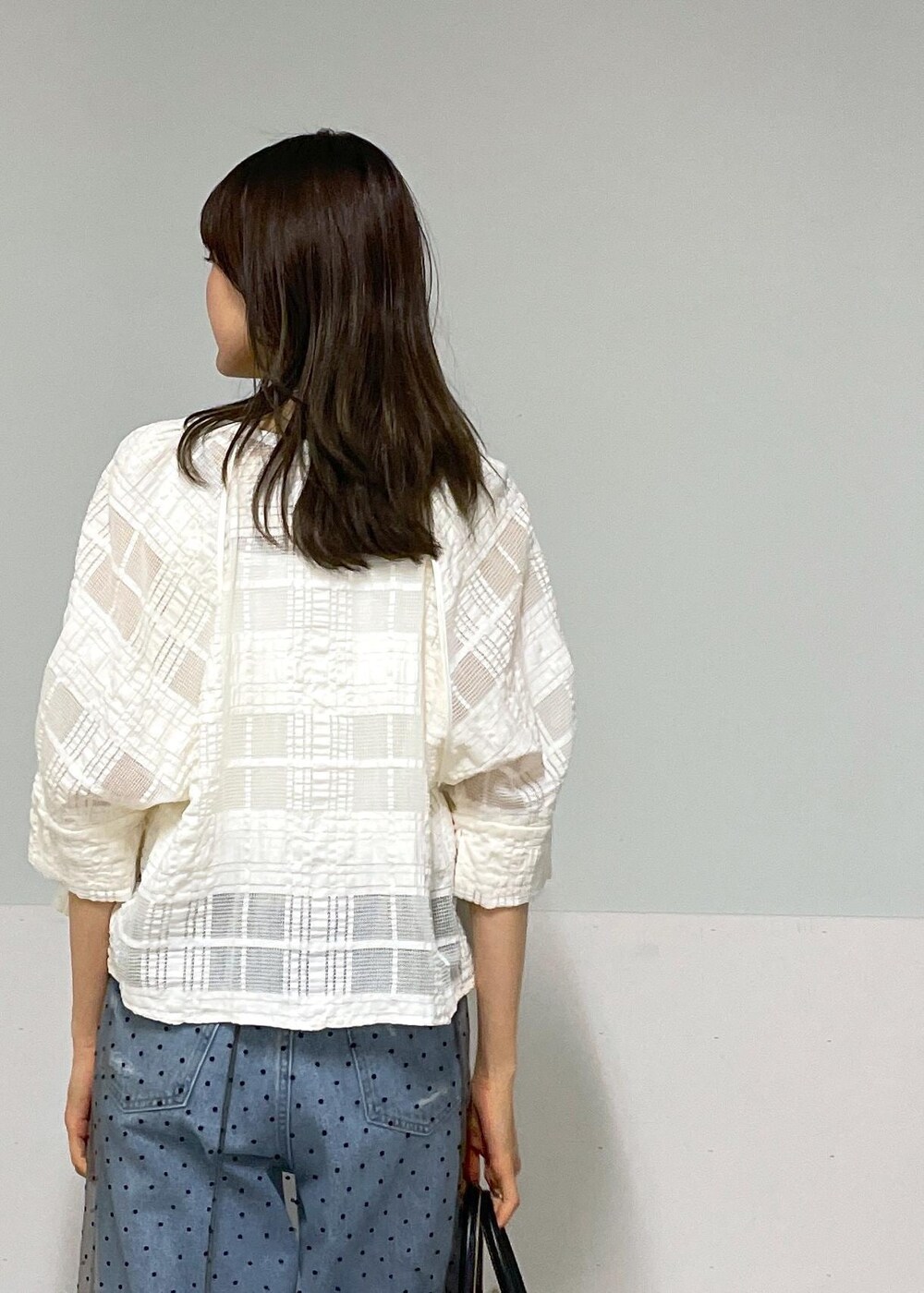 ブラック系のトートバッグ、ホワイト系のタンクトップ、グレー系のスカートを着用したレディースの夏コーディネートの7枚目の写真