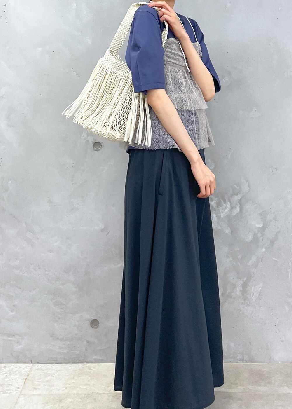 ホワイト系のハンドバッグ、ブルー系のTシャツ/カットソー、ブラウン系のキャミソールを着用したレディースの春コーディネートの2枚目の写真