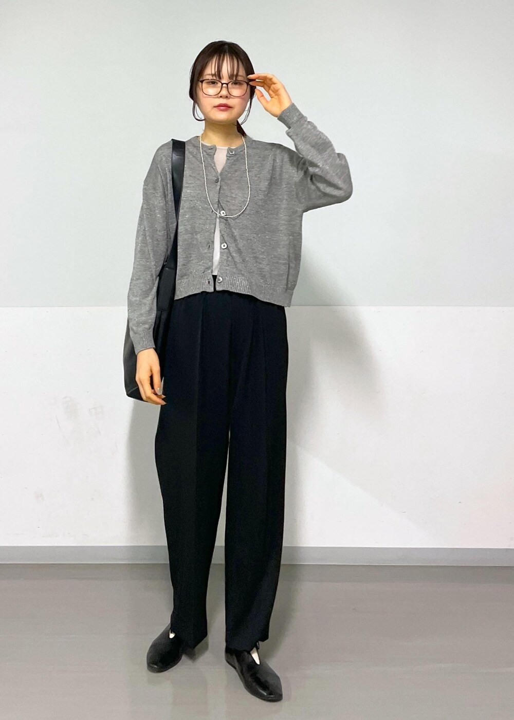 グレー系のカーディガン/ボレロ、グレー系のTシャツ/カットソー、ブラック系のスラックスを着用したレディースの春コーディネートの6枚目の写真