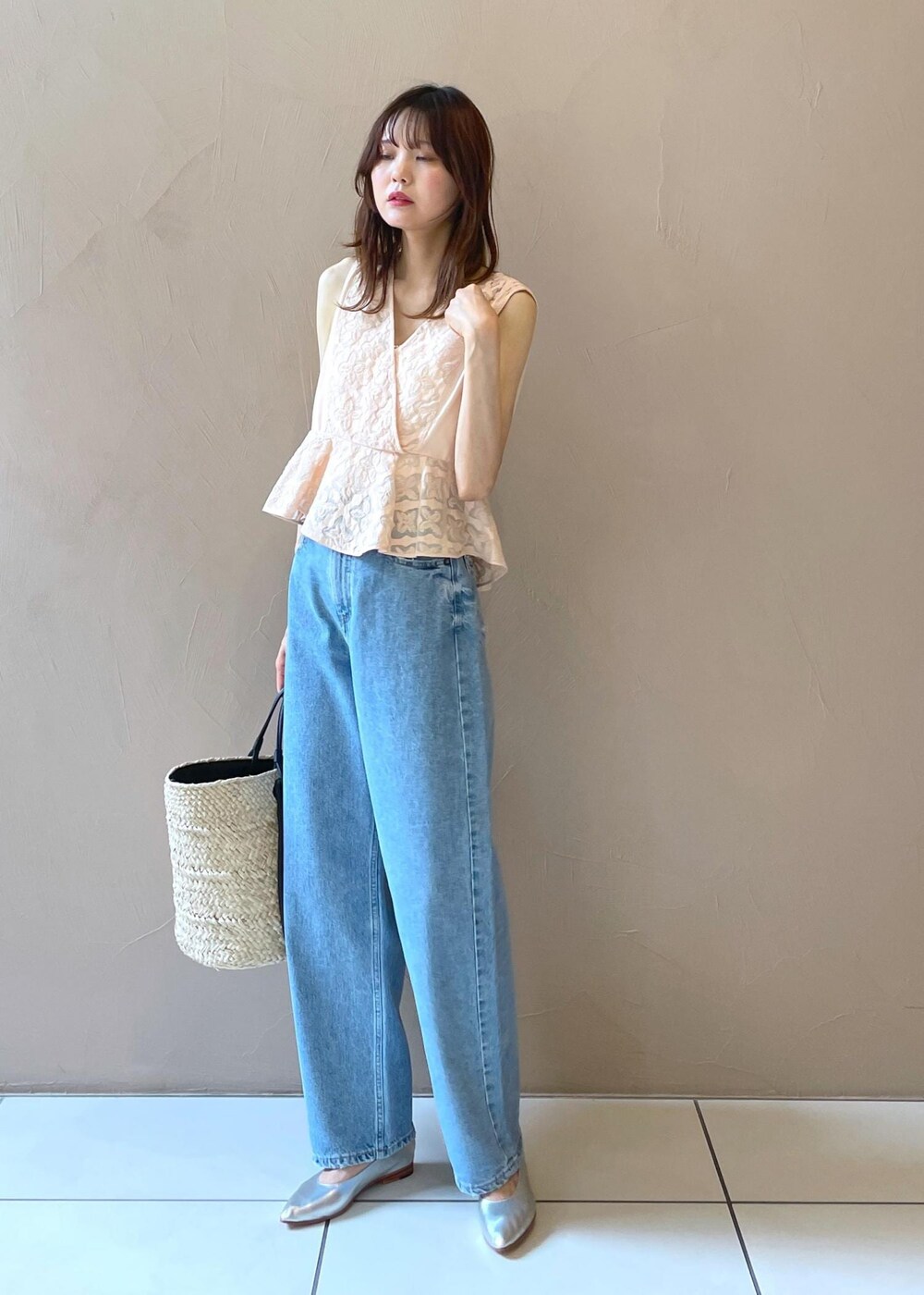 ホワイト系のかごバッグ、ブルー系のデニムパンツ、シルバー系のパンプスを着用したレディースの夏コーディネートの9枚目の写真