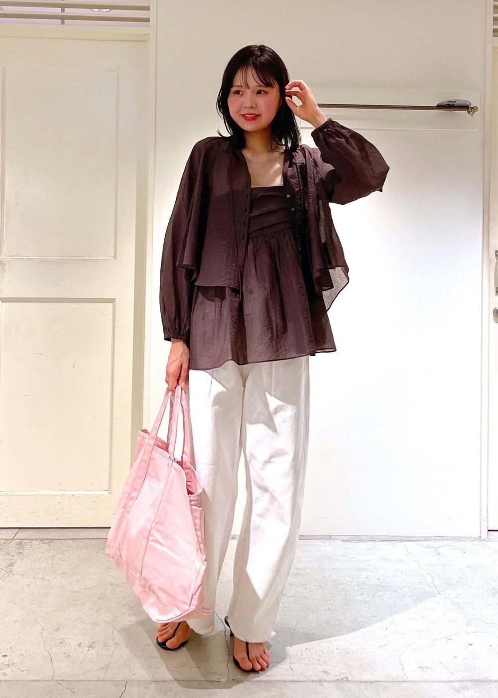 グレー系のタンクトップ、ブラック系のサンダル、ホワイト系のデニムパンツを着用したレディースの夏コーディネートの8枚目の写真