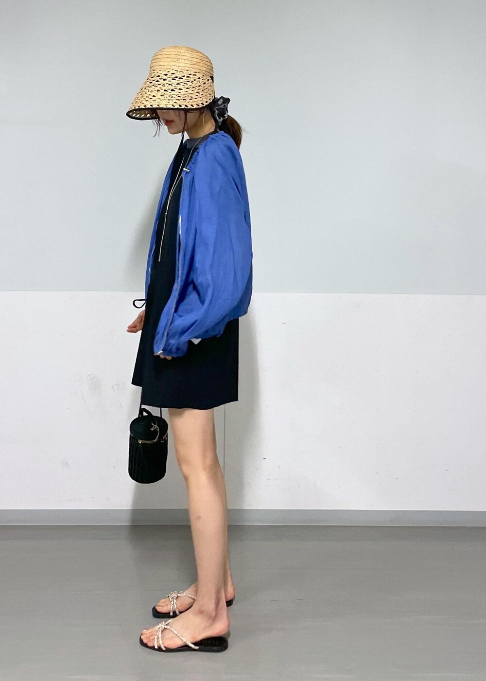 ブラック系のショルダーバッグ、ゴールド系のサンダル、ブラック系のTシャツ/カットソーを着用したレディースの夏コーディネートの3枚目の写真