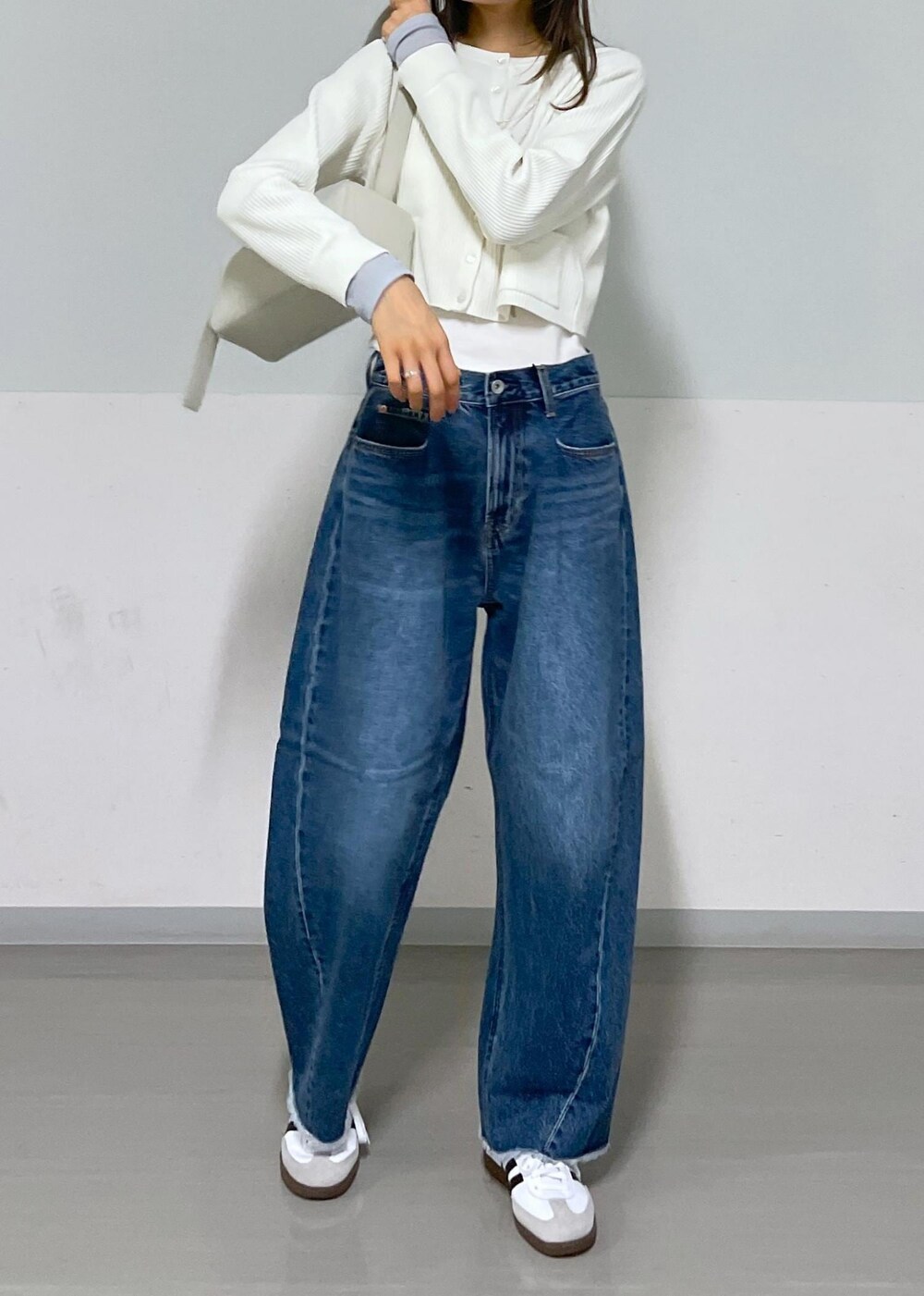 グレー系のショルダーバッグ、ホワイト系のカーディガン/ボレロ、グレー系のTシャツ/カットソーを着用したレディースの夏コーディネートの4枚目の写真