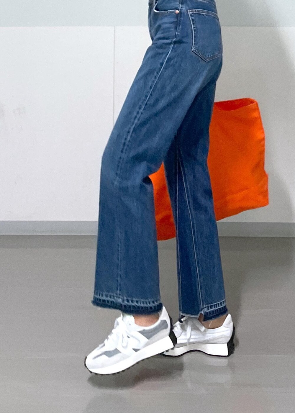 グレー系のタンクトップ、ブラック系のカーディガン/ボレロ、ブルー系のデニムパンツを着用したレディースの秋コーディネートの3枚目の写真