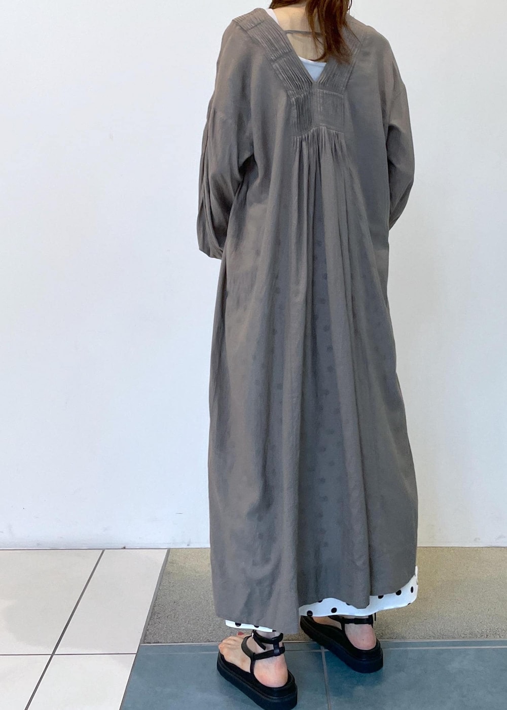 ブラック系のサンダル、グレー系のワンピース、ベージュ系のハットを着用したレディースの夏コーディネートの7枚目の写真