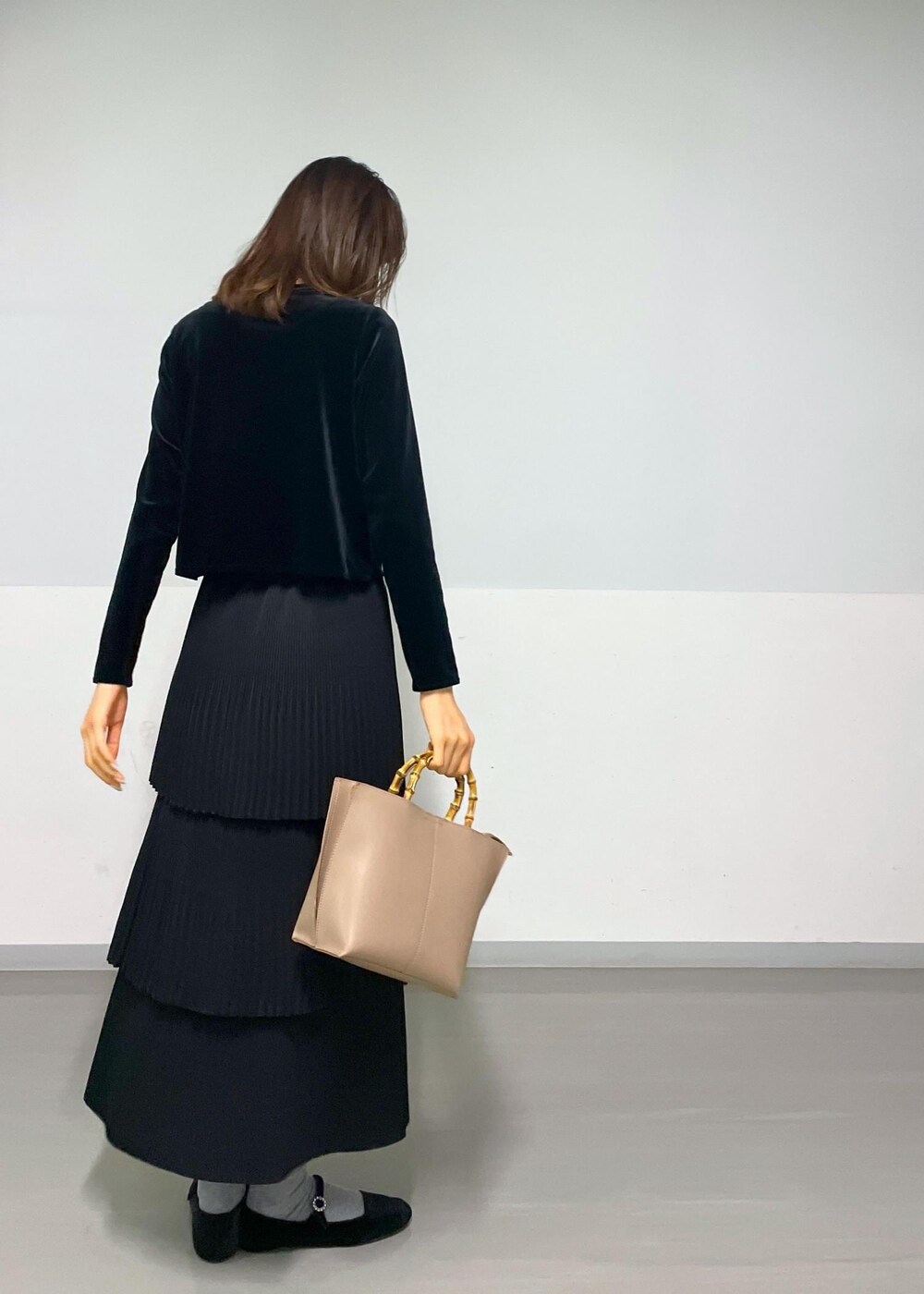 ブラック系のカーディガン/ボレロ、ブラック系のスカート、ベージュ系のハンドバッグを着用したレディースの冬コーディネートの10枚目の写真