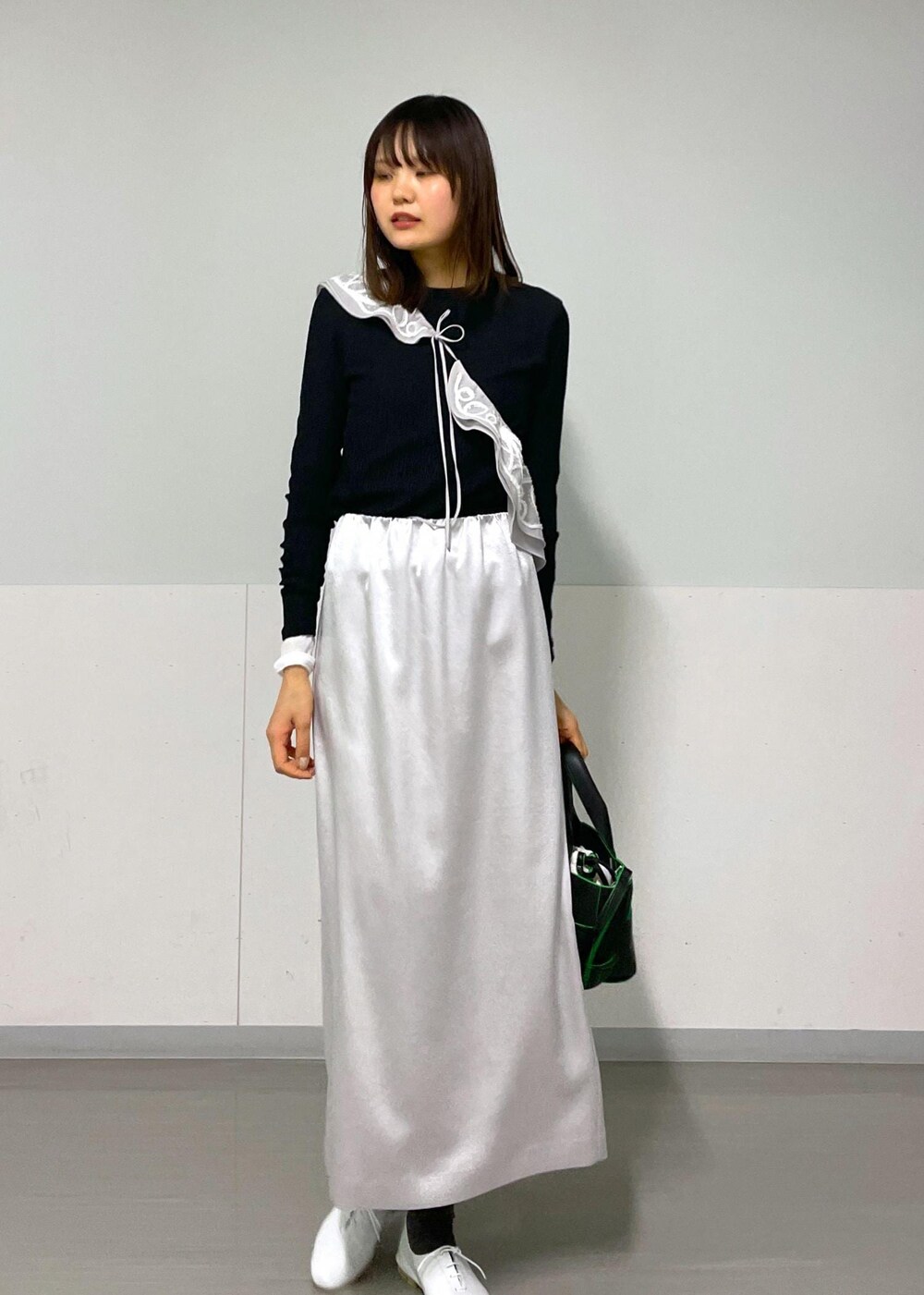 ブラック系のトートバッグ、ホワイト系のその他シューズ、ブラック系のTシャツ/カットソーを着用したレディースの冬コーディネートの3枚目の写真