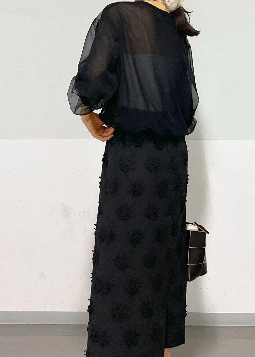 ブラック系のトートバッグ、ホワイト系のキャミソール、ブラック系のTシャツ/カットソーを着用したレディースの春コーディネートの9枚目の写真