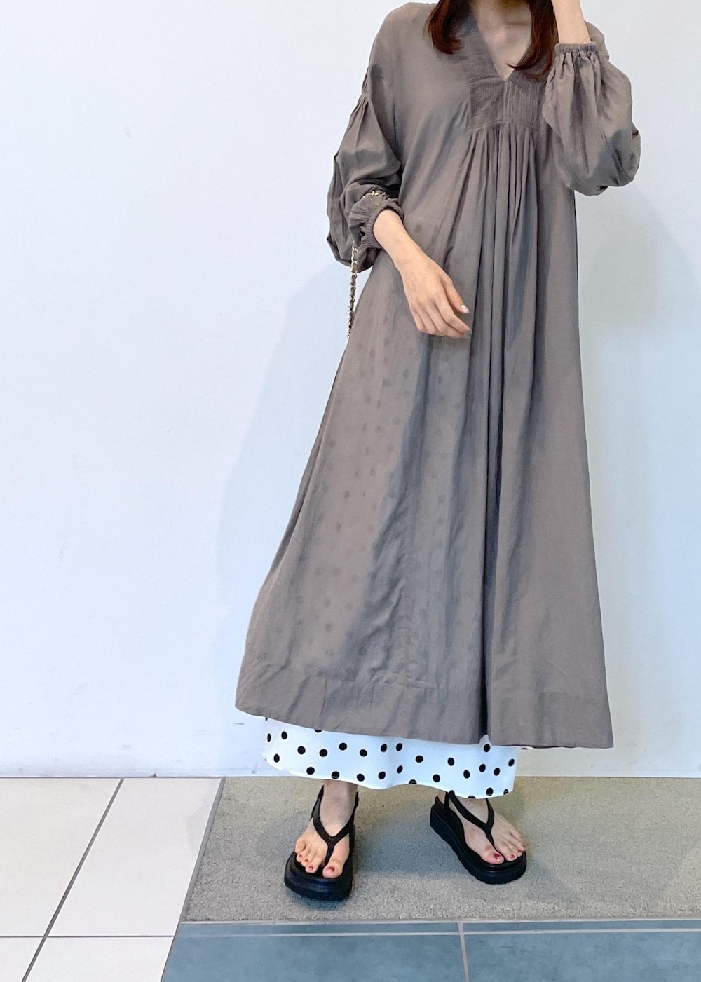 ブラック系のサンダル、グレー系のワンピース、ベージュ系のハットを着用したレディースの夏コーディネートの8枚目の写真