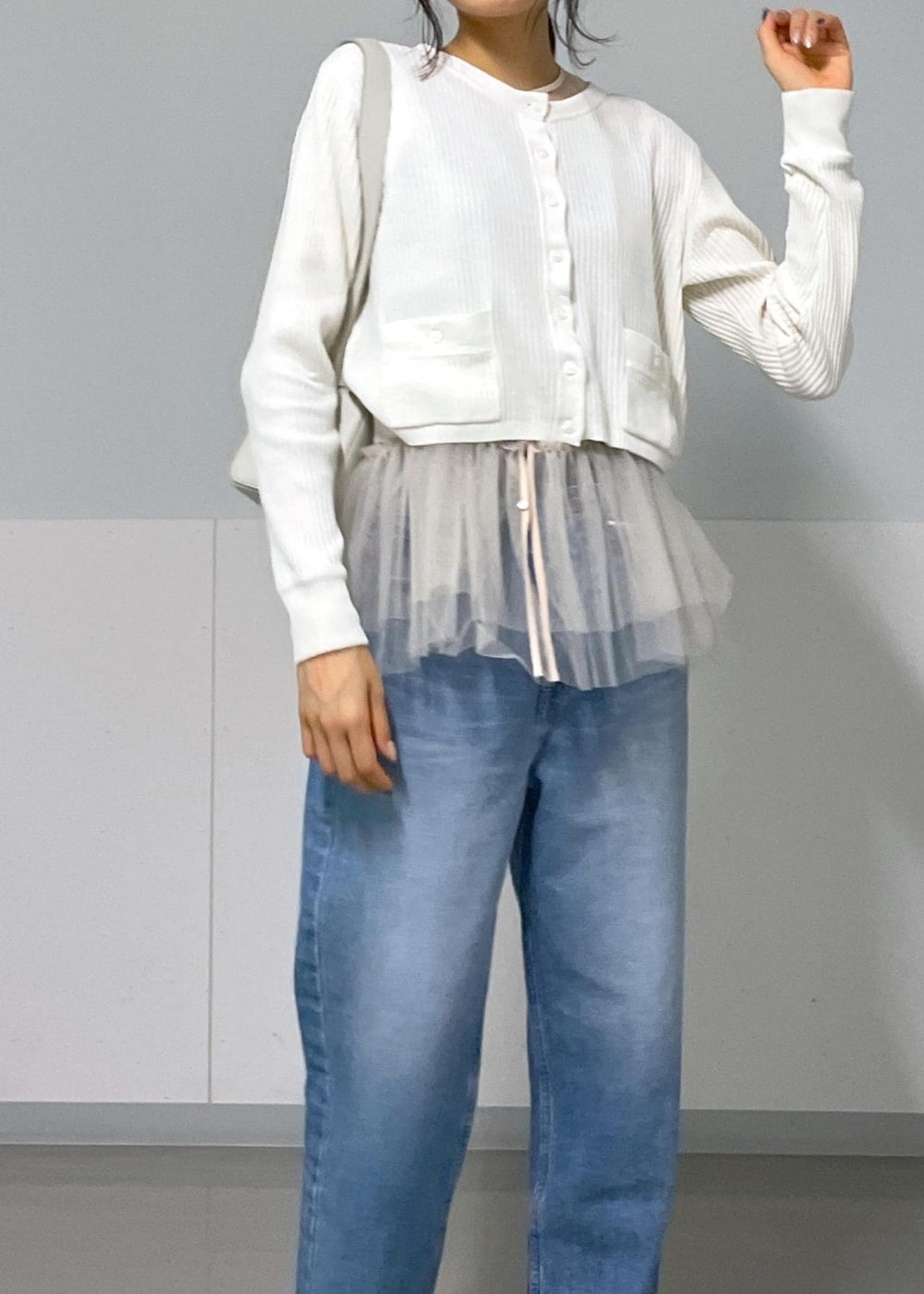 ブラック系のバレエシューズ、ホワイト系のカーディガン/ボレロ、ブルー系のデニムパンツを着用したレディースの秋コーディネートの9枚目の写真