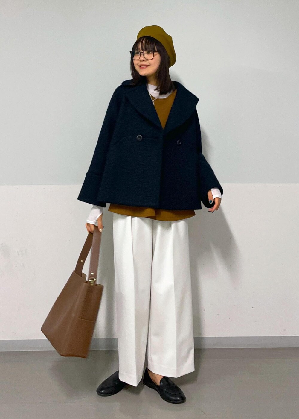ブルー系のピーコート、ブラウン系のTシャツ/カットソー、ホワイト系のその他パンツを着用したレディースの秋コーディネートの6枚目の写真