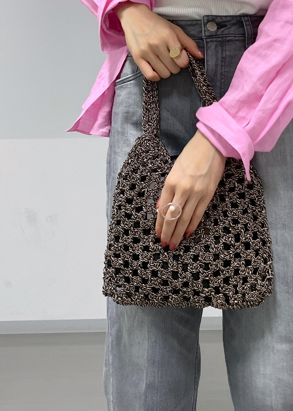 ブラック系のデニムパンツ、ブラック系のサンダル、ブラック系のハンドバッグを着用したレディースの春コーディネートの6枚目の写真