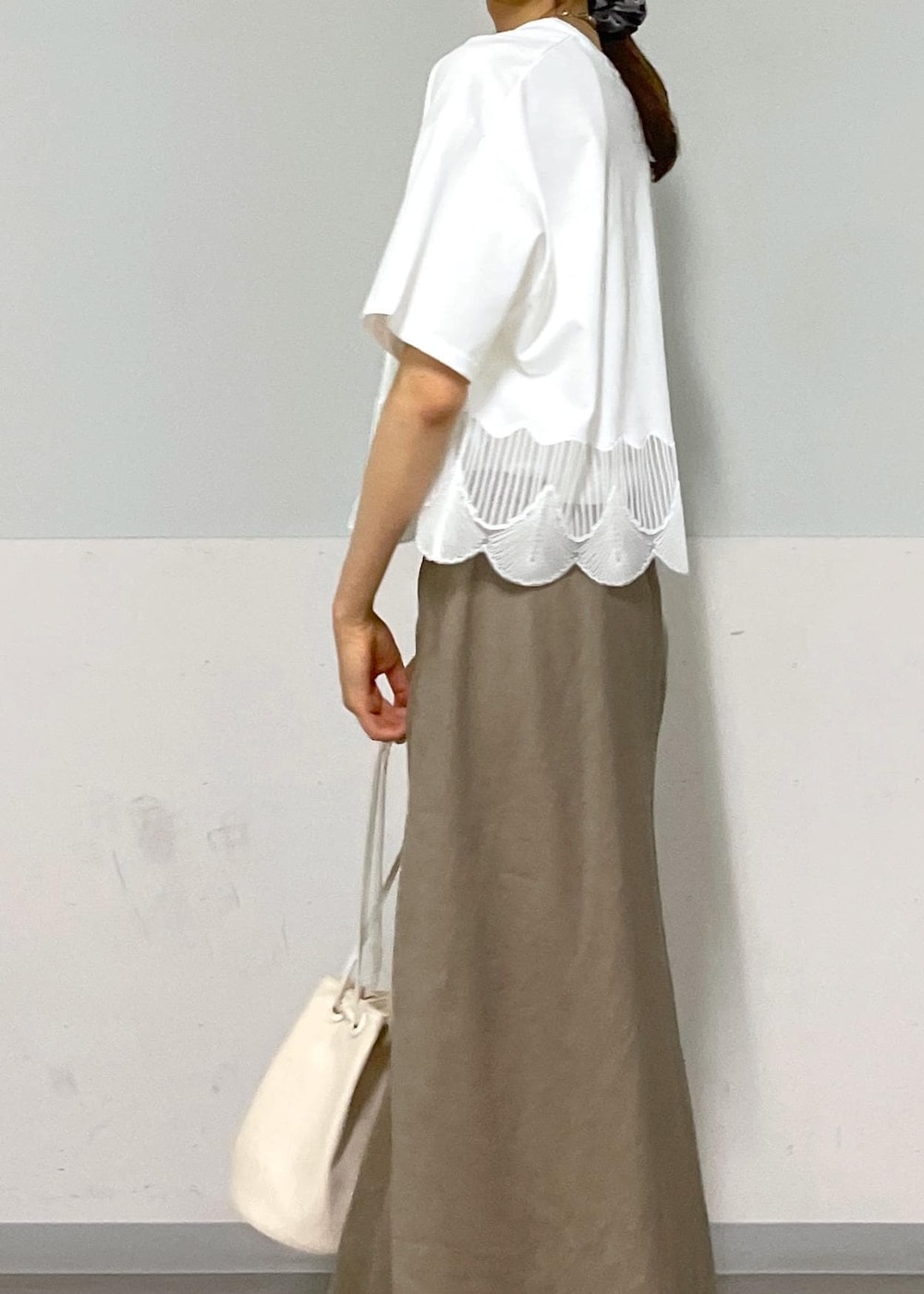 ホワイト系のキャミソール、シルバー系のサンダル、グリーン系のスカートを着用したレディースの夏コーディネートの7枚目の写真