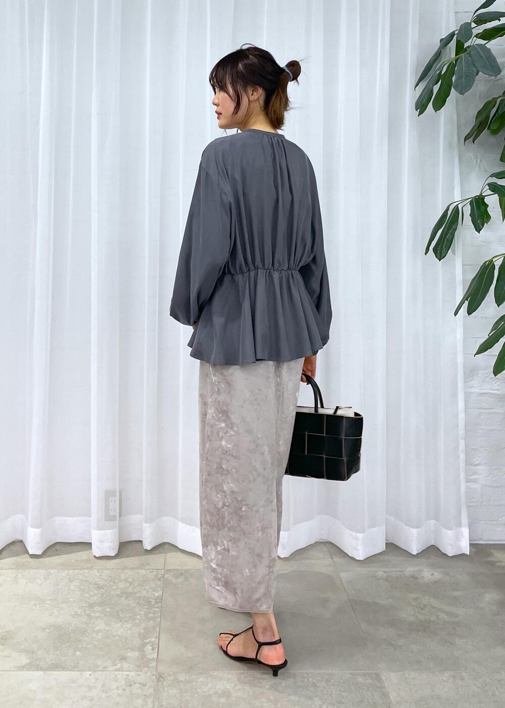 ブラック系のトートバッグ、ベージュ系のスカート、グレー系のシャツ/ブラウスを着用したレディースの冬コーディネートの9枚目の写真