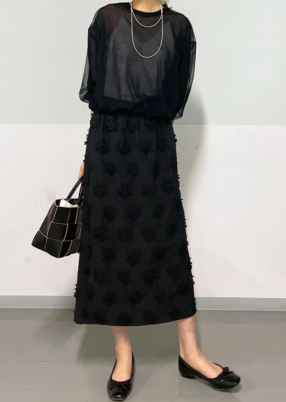 ブラック系のトートバッグ、ホワイト系のキャミソール、ブラック系のTシャツ/カットソーを着用したレディースの春コーディネートの7枚目の写真