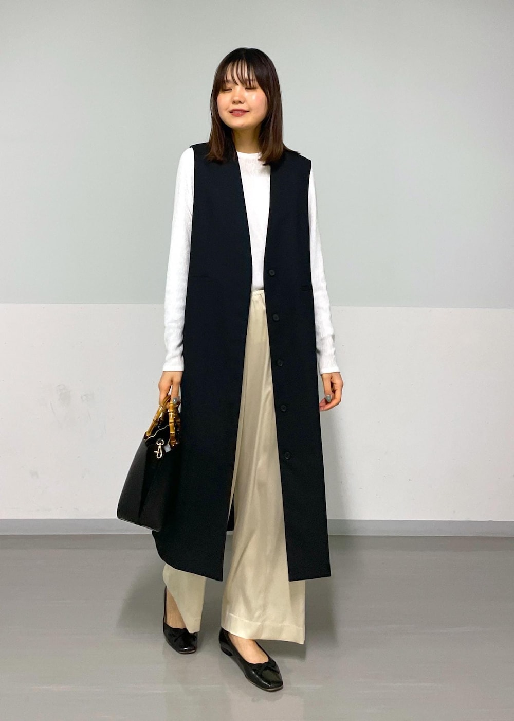 ベージュ系のその他パンツ、ブラック系のジャンパースカート、ホワイト系のTシャツ/カットソーを着用したレディースの冬コーディネートの8枚目の写真