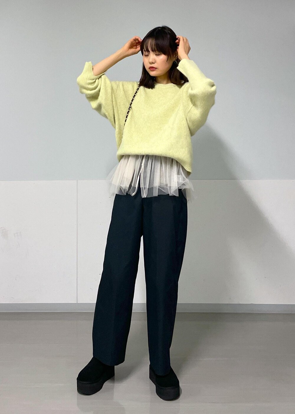 ブラック系のショルダーバッグ、ブラック系のその他パンツ、イエロー系のニット/セーターを着用したレディースの秋コーディネートの4枚目の写真