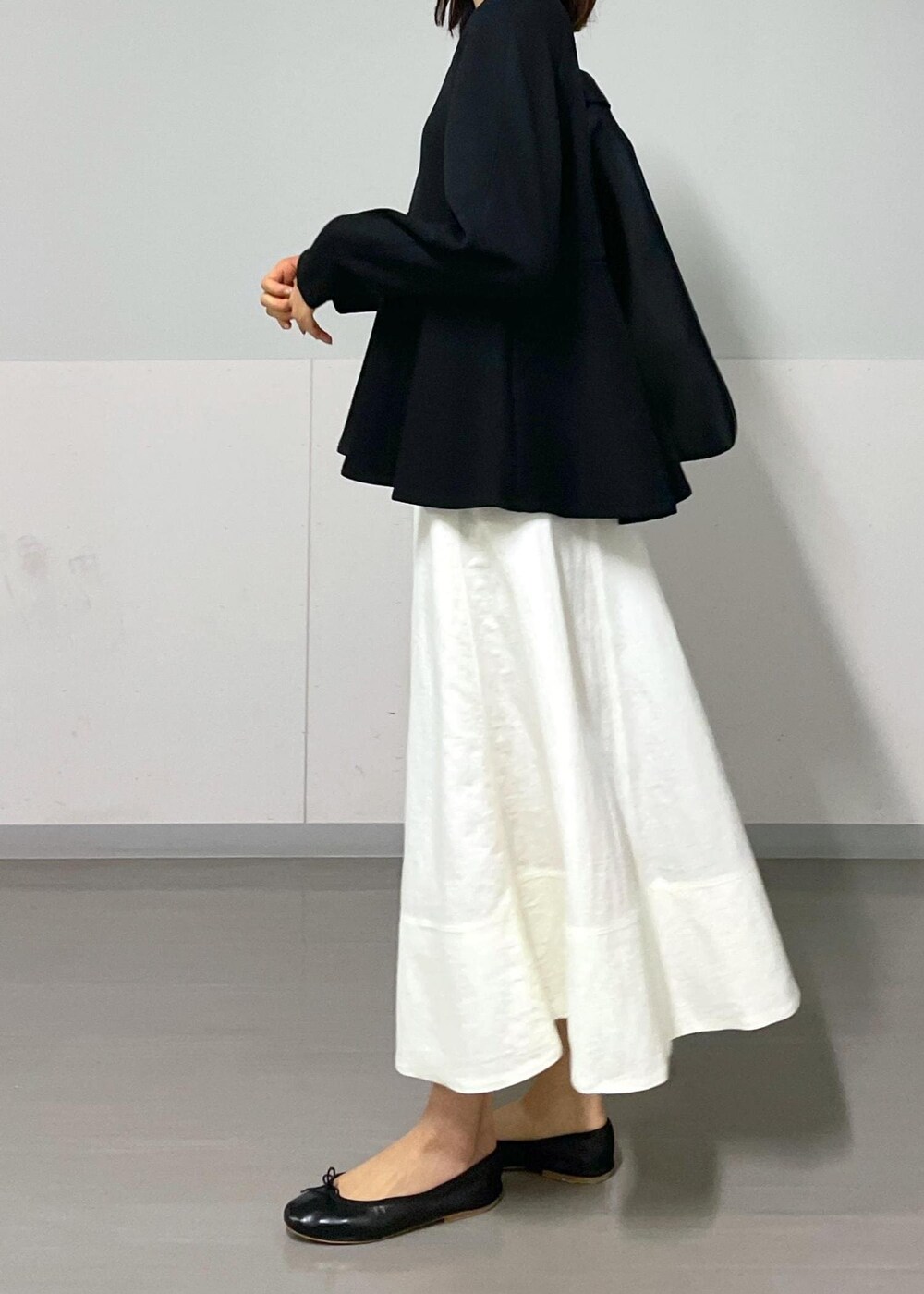 ブラック系のバレエシューズ、ホワイト系のスカート、ブラック系のTシャツ/カットソーを着用したレディースの秋コーディネートの8枚目の写真