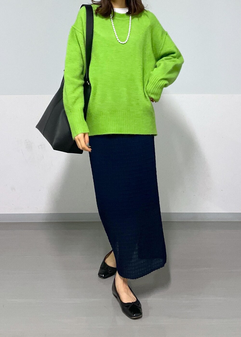 グリーン系のニット/セーター、ホワイト系のTシャツ/カットソー、ブラック系のトートバッグを着用したレディースの冬コーディネートの7枚目の写真