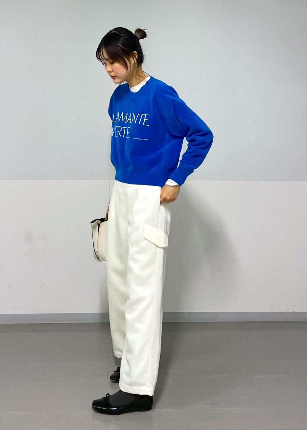 ブルー系のニット/セーター、ホワイト系のカーゴパンツ、ホワイト系のTシャツ/カットソーを着用したレディースの冬コーディネートの7枚目の写真