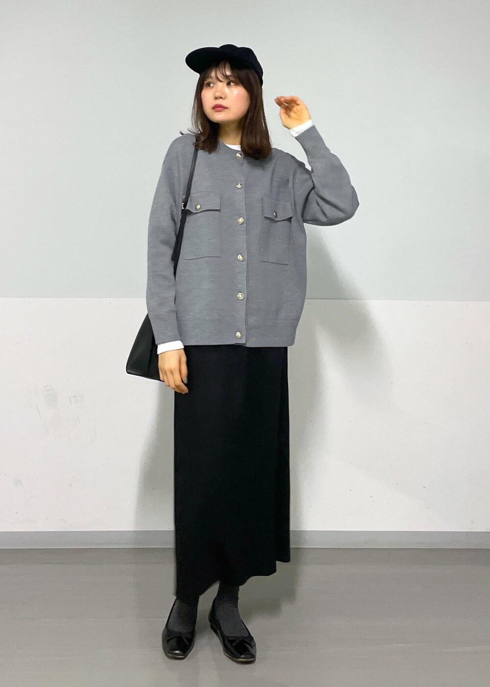 グレー系のカーディガン/ボレロ、ホワイト系のTシャツ/カットソー、ブラック系のハンドバッグを着用したレディースの冬コーディネートの9枚目の写真