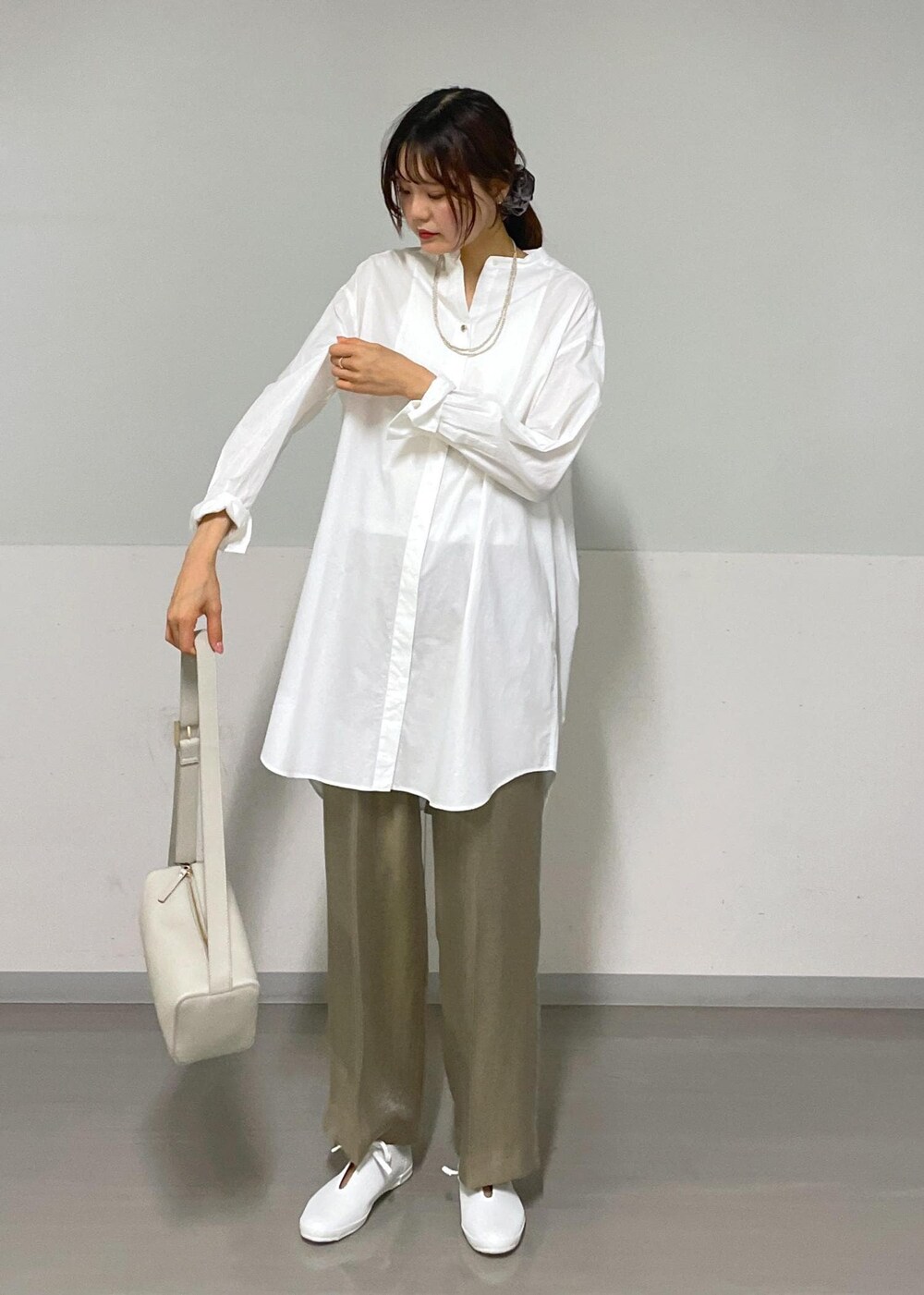 グレー系のその他パンツ、グレー系のショルダーバッグ、ホワイト系のシャツ/ブラウスを着用したレディースの夏コーディネートの3枚目の写真