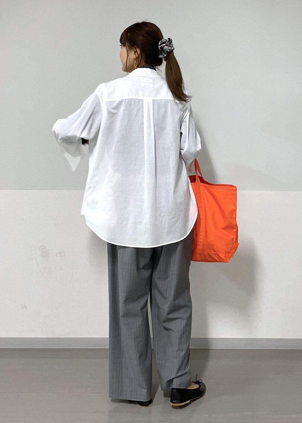 ブルー系のTシャツ/カットソー、グレー系のスラックス、ホワイト系のシャツ/ブラウスを着用したレディースの夏コーディネートの5枚目の写真