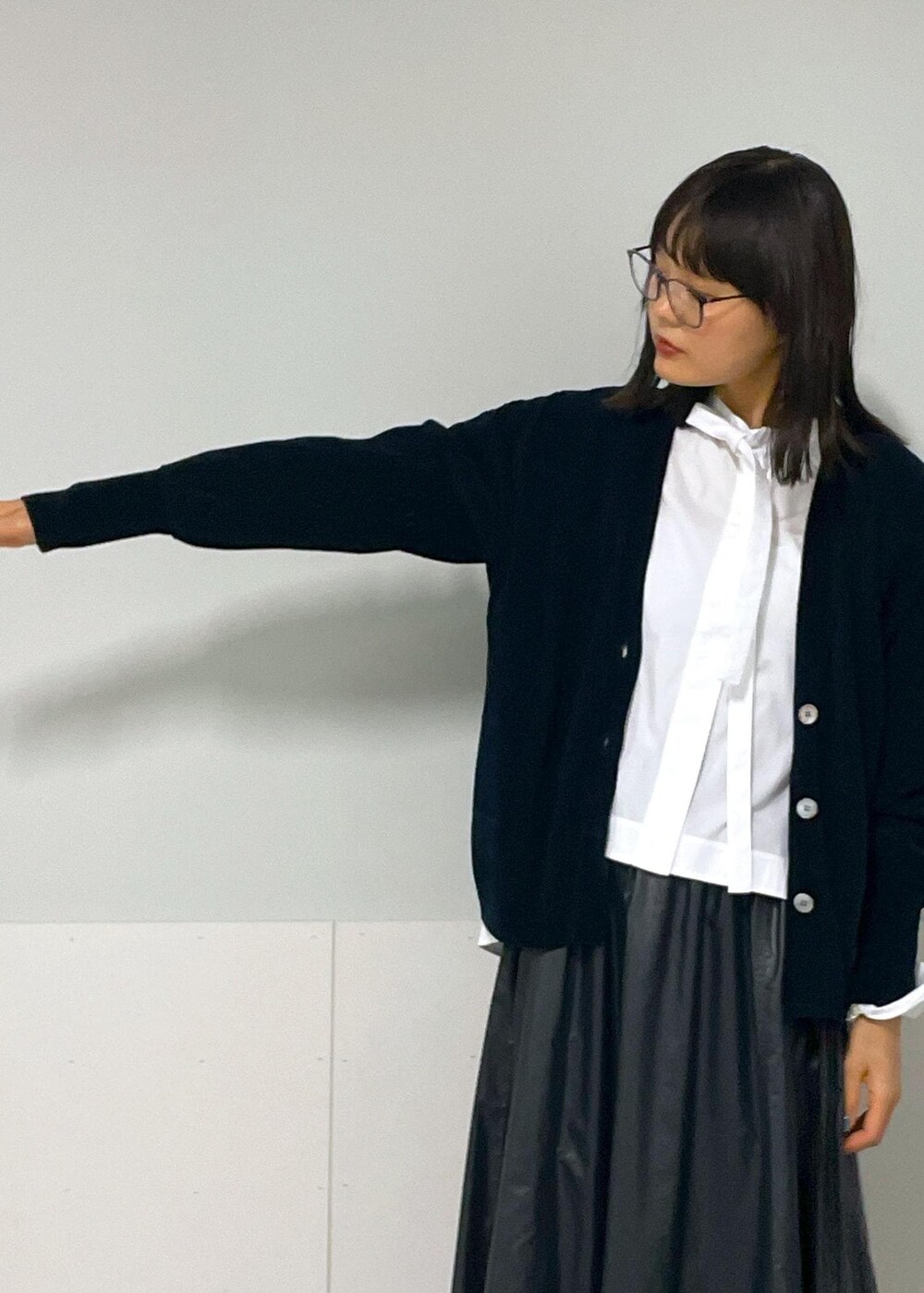 ブラック系のスカート、ブラック系のカーディガン/ボレロ、ホワイト系のシャツ/ブラウスを着用したレディースの秋コーディネートの8枚目の写真