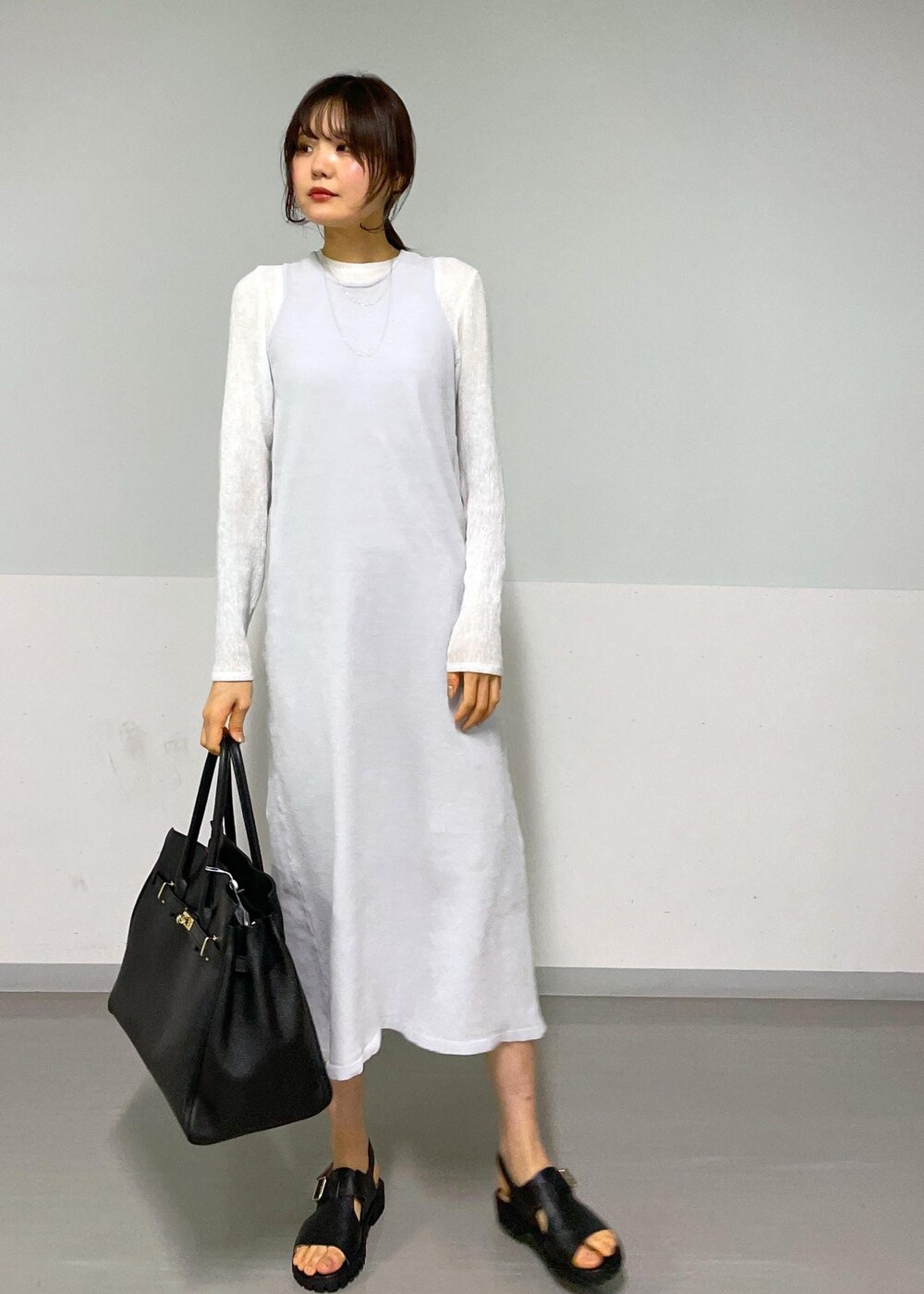 ブラック系のサンダル、グレー系のワンピース、ホワイト系のTシャツ/カットソーを着用したレディースの冬コーディネートの7枚目の写真