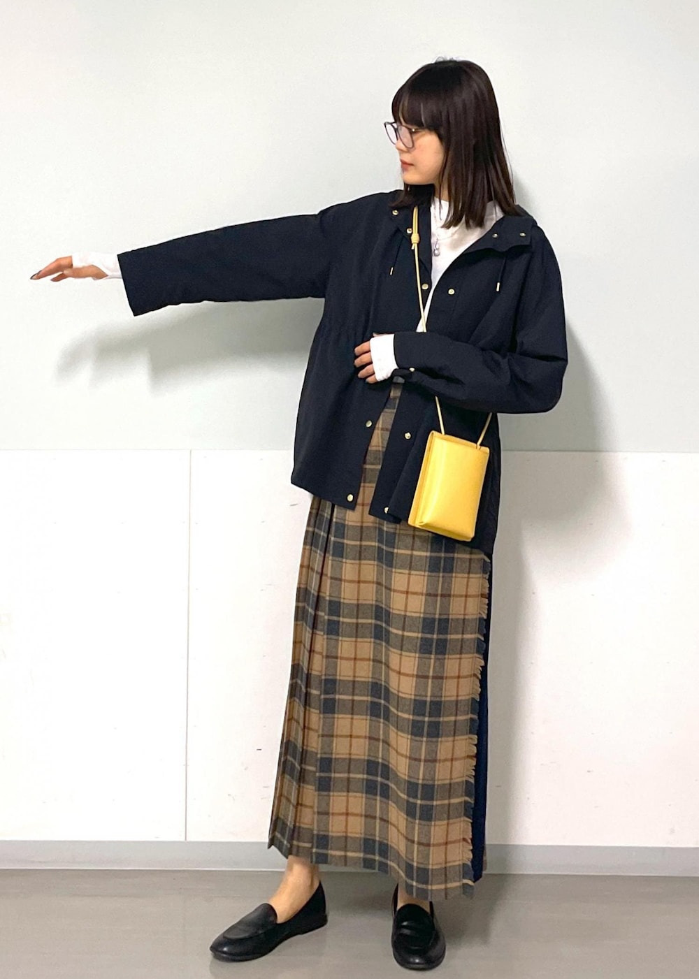 イエロー系のショルダーバッグ、ホワイト系のTシャツ/カットソー、ベージュ系のスカートを着用したレディースの秋コーディネートの3枚目の写真